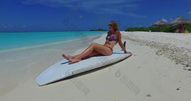 年轻的美模型放松海海滩清洁白色沙子蓝色的背景